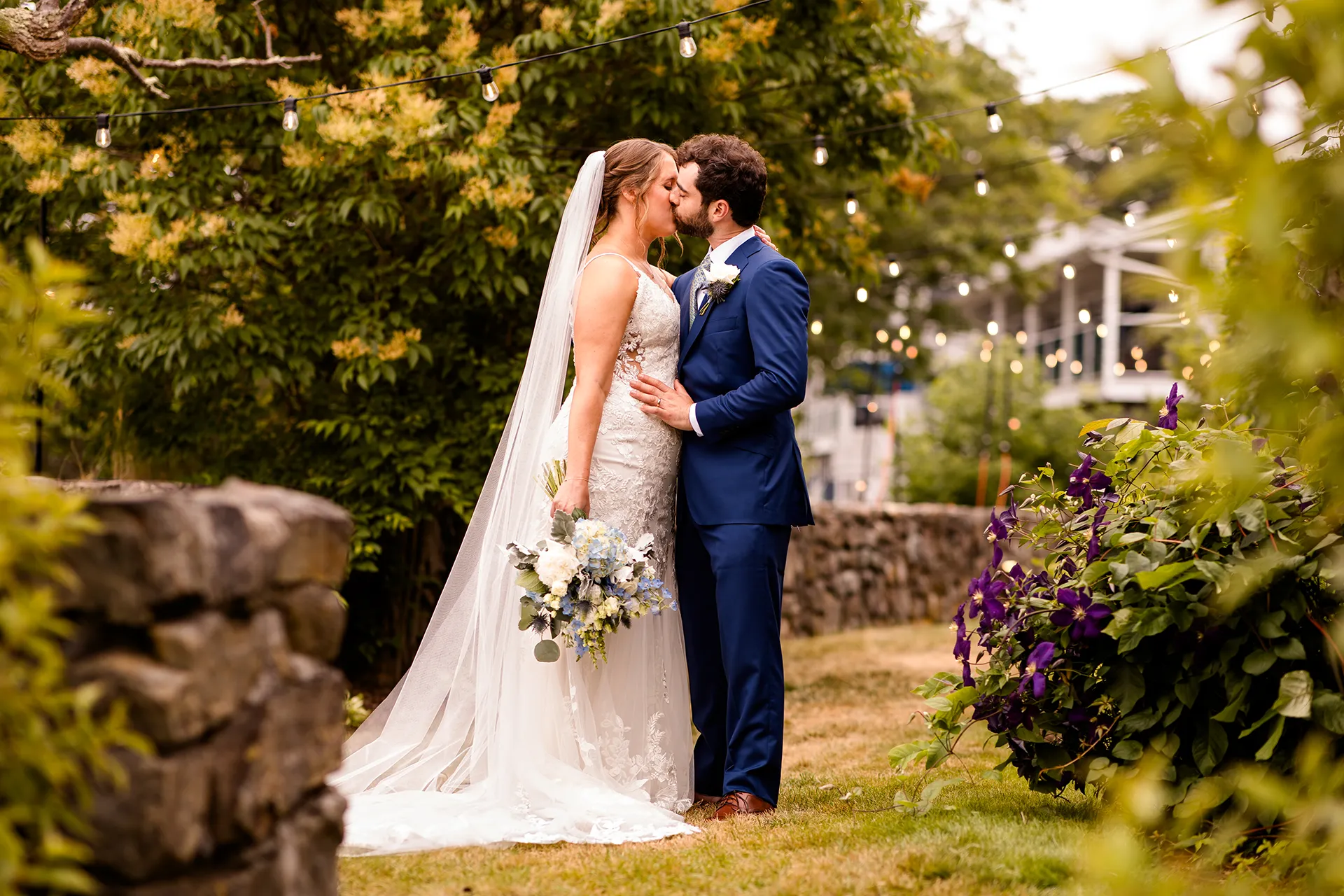 maine wedding photography meghan phil 28 A bride and groom kiss in a garden during wedding portraits at the Atlantic Oceanside Hotel & Event Center in Bar Harbor, Maine.