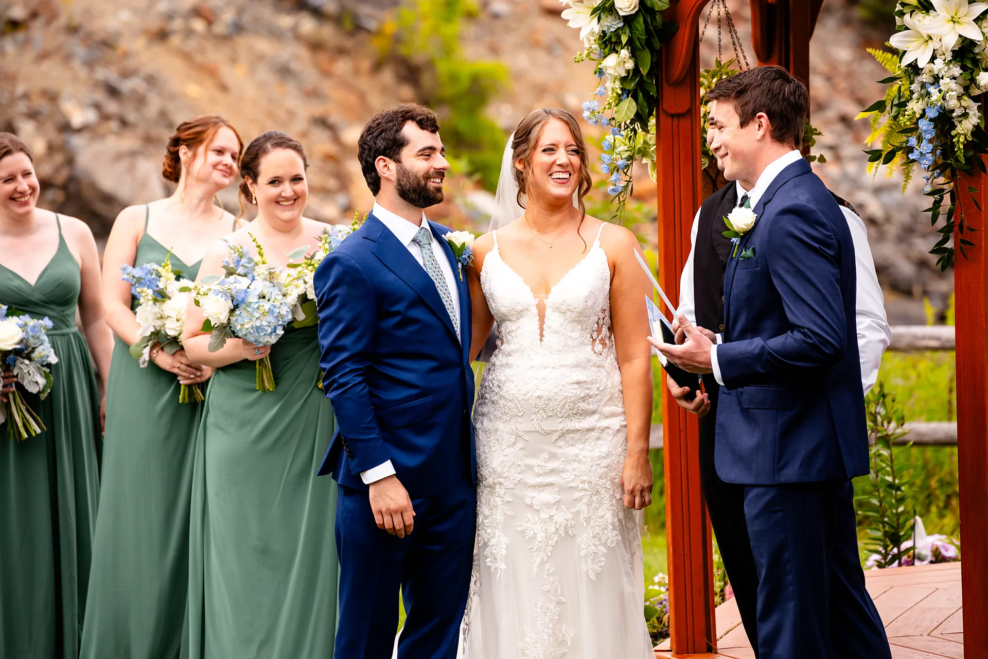 maine wedding photography meghan phil 33 A couple laughs as a groomsman does a reading during a wedding ceremony at the Atlantic Oceanside Hotel & Event Center in Bar Harbor, Maine.