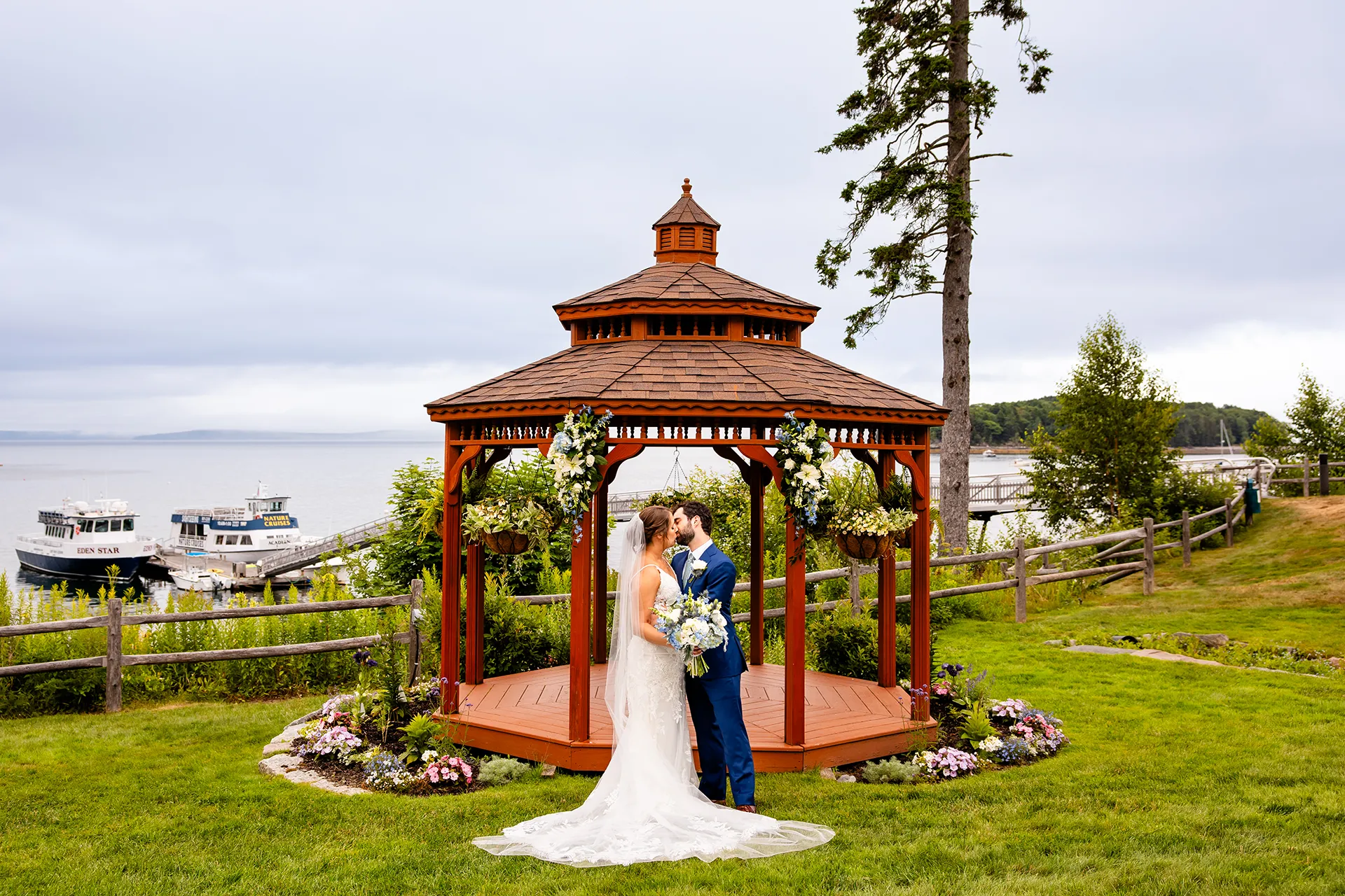 maine wedding photography meghan phil 40 A newly married couple kiss in front of a gazebo during a wedding portraits at the Atlantic Oceanside Hotel & Event Center in Bar Harbor, Maine.
