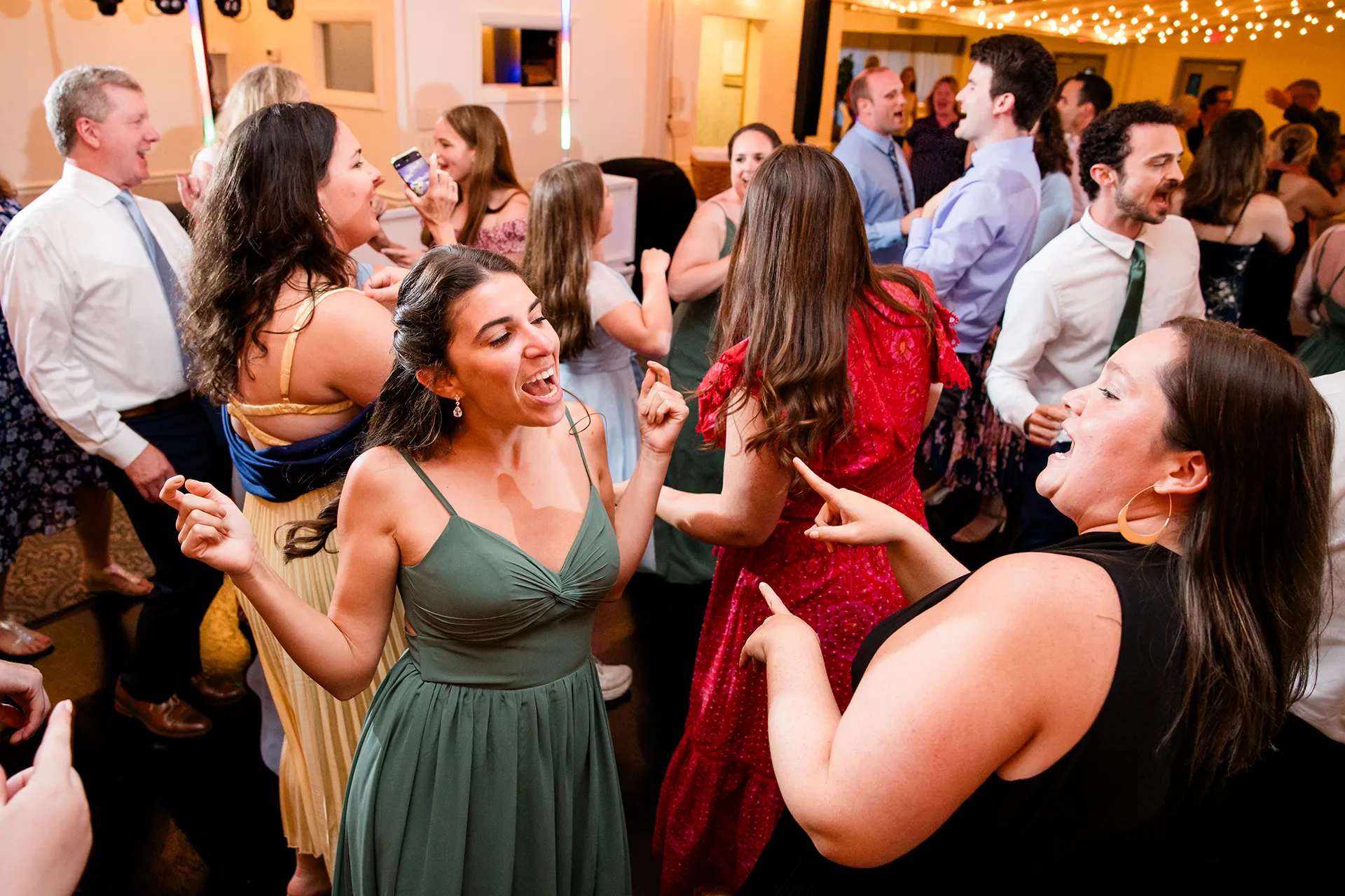 maine wedding photography meghan phil 58 A bridesmaid dances with guest during a wedding reception at the Atlantic Oceanside Hotel & Event Center in Bar Harbor, Maine.