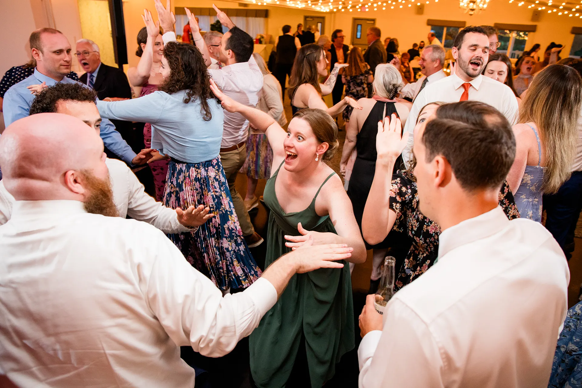 maine wedding photography meghan phil 59 A bridesmaid dances with guests during a wedding reception at the Atlantic Oceanside Hotel & Event Center in Bar Harbor, Maine.