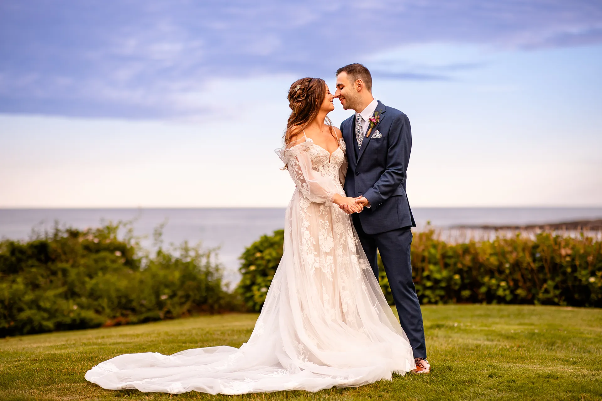 A bride and groom smile as they rub noses during wedding portraits at the Hartley Mason Reserve in York, Maine.