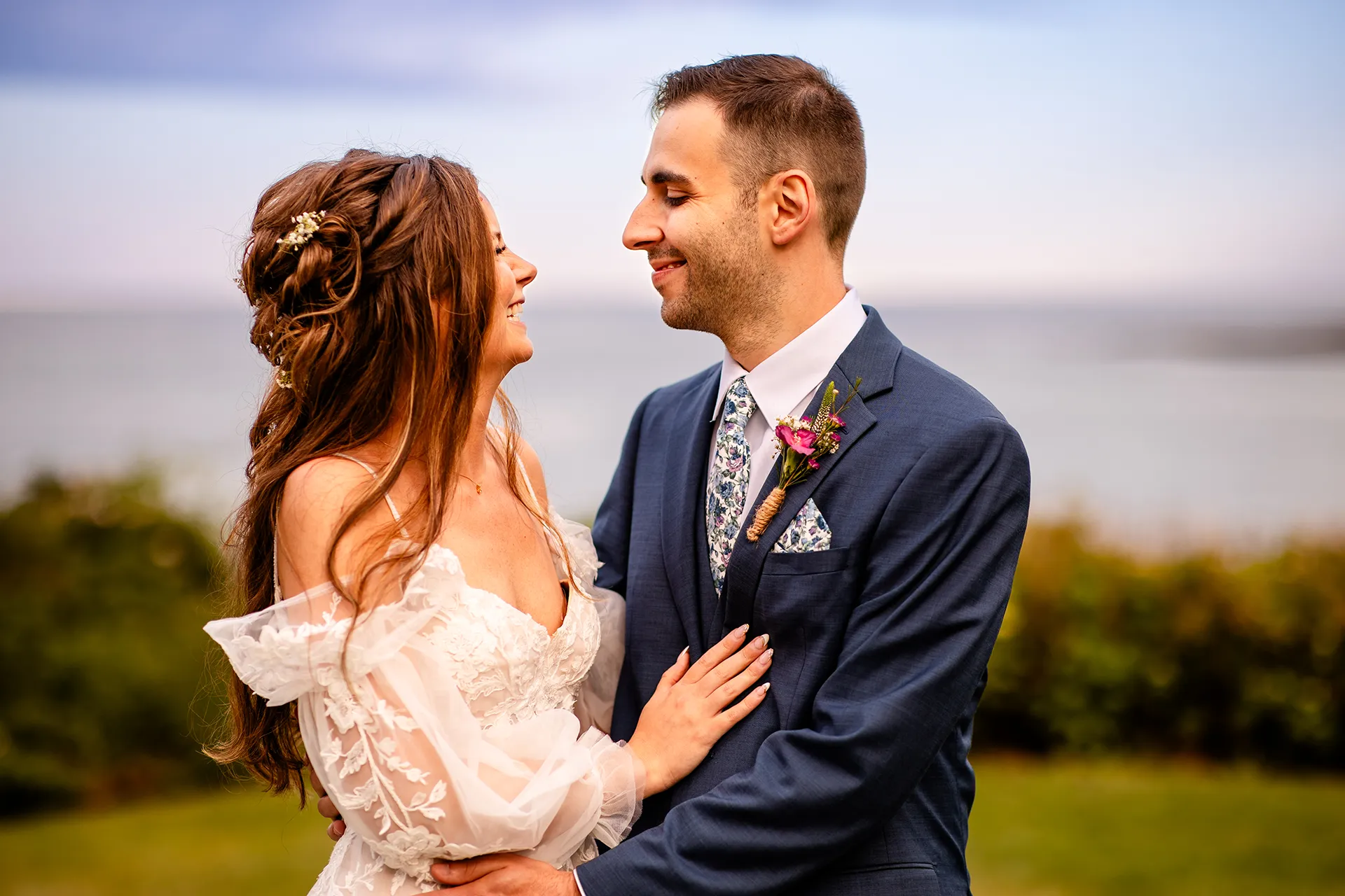 A bride and groom laugh during wedding portraits at the Hartley Mason Reserve near the York Harbor Reading Room in York, Maine.