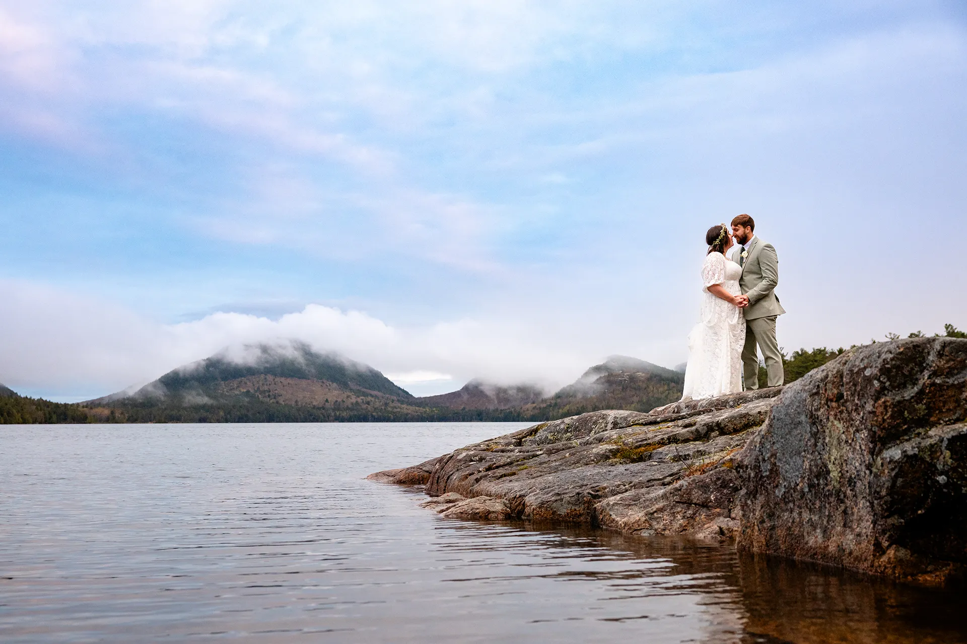 maine wedding photography mystic andrew 10 A bride and groom stand on a rock and smile at each other during wedding portraits at Eagle Lake in Acadia National Park near Bar Harbor, Maine.