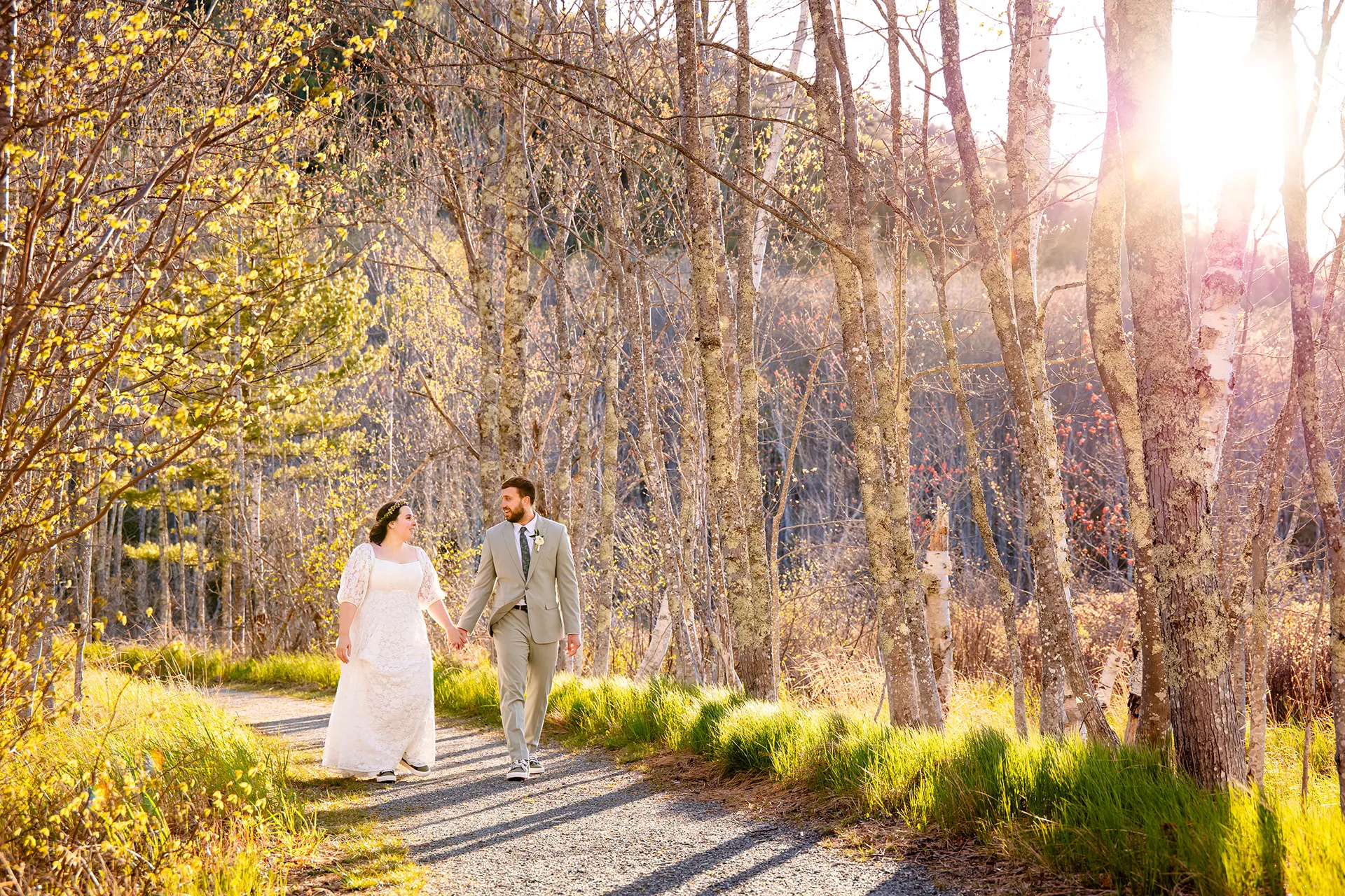 maine wedding photography mystic andrew 25 A bride and groom hold hands as they walk along the Hemlock Trail in Acadia National Park near Bar Harbor, Maine.