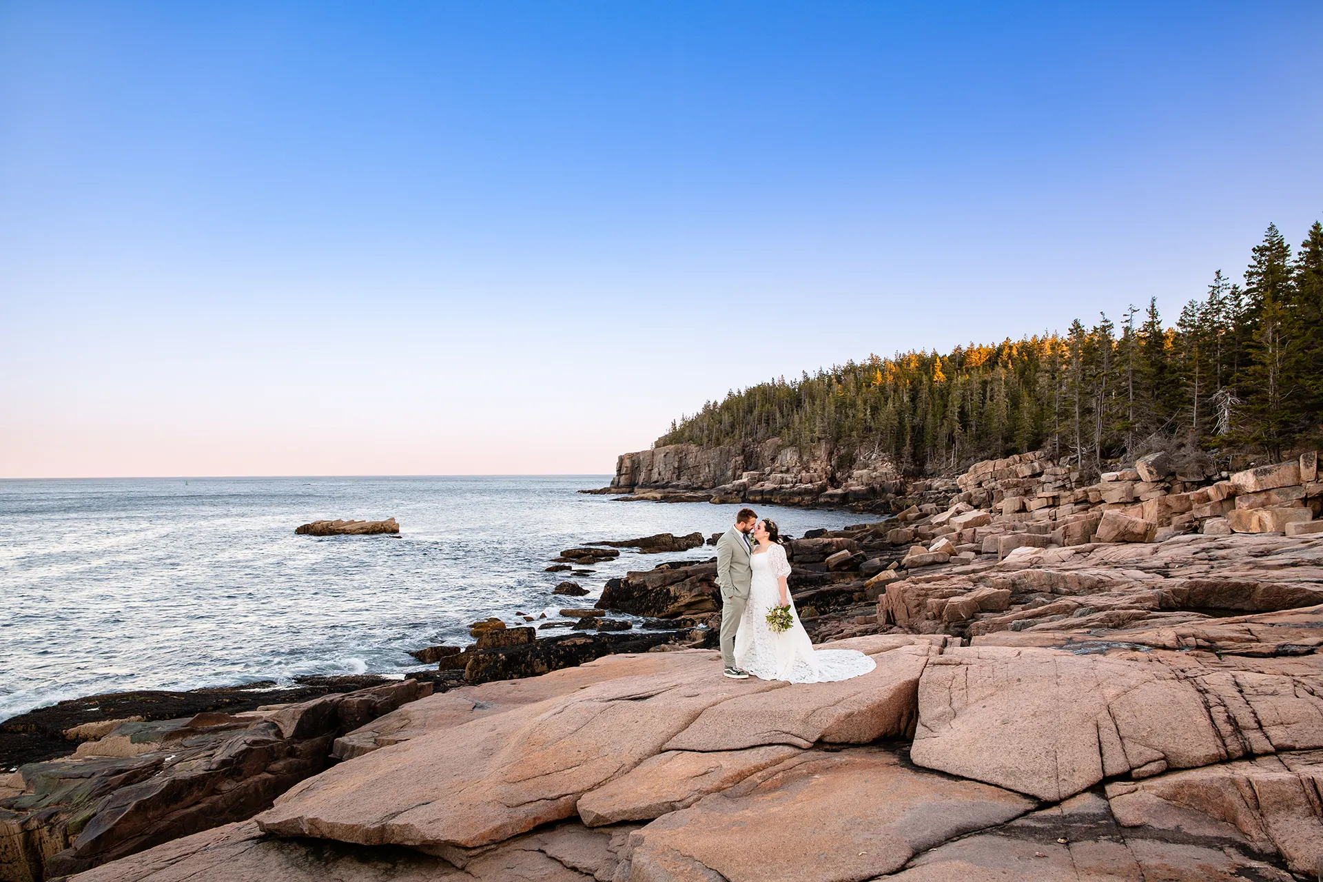 maine wedding photography mystic andrew 29 A bride and groom smile at each other during wedding portraits near Otter Cliff at Acadia National Park in Bar Harbor, Maine.