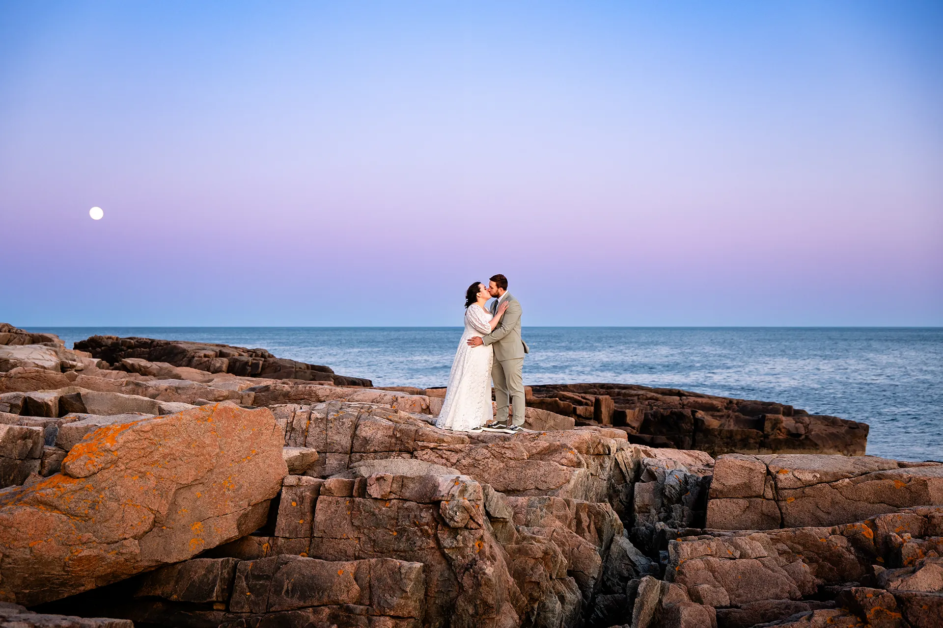 maine wedding photography mystic andrew 32 A bride and groom kiss on a cliff during sunset wedding portraits at Otter Point in Acadia National Park near Bar Harbor, Maine.
