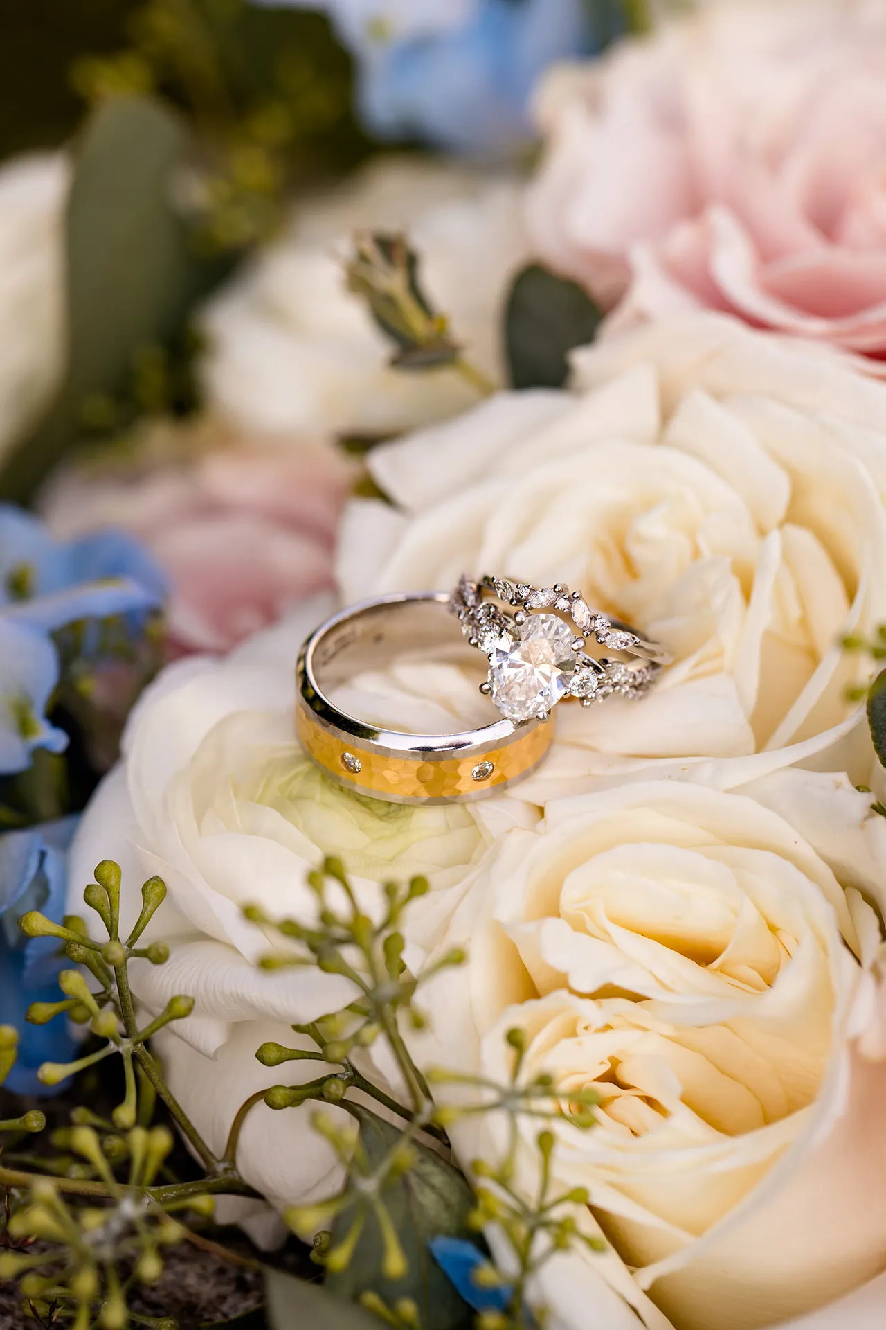 A closeup of wedding rings sitting on white roses at the Bar Harbor Inn and Spa in Bar Harbor, Maine.