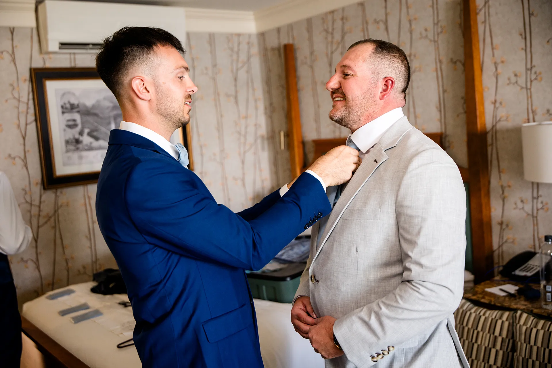 A groomsman helps a groom get ready for a wedding at the Bar Harbor Inn and Spa in Bar Harbor, Maine.