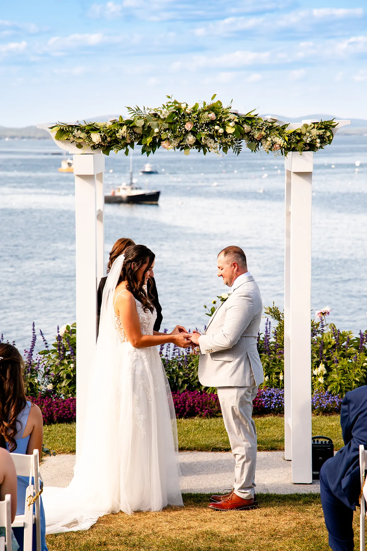 A bride puts a ring slides a ring on the grooms ringer during a wedding ceremony at the Bar Harbor Inn and Spa in Bar Harbor, Maine.