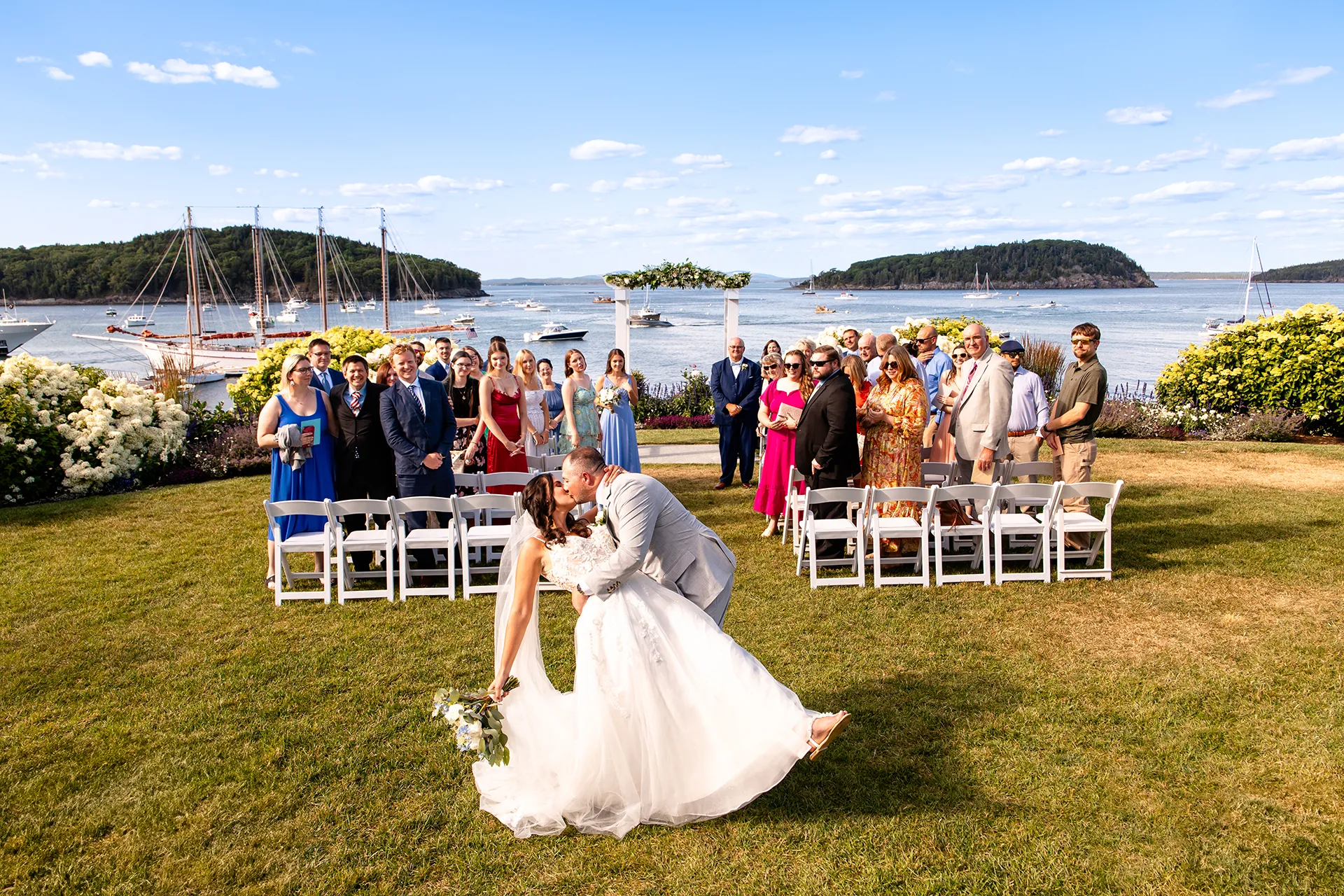A newly married couple dip and kiss at the end of the aisle after getting married at the Bar Harbor Inn and Spa in Bar Harbor, Maine.