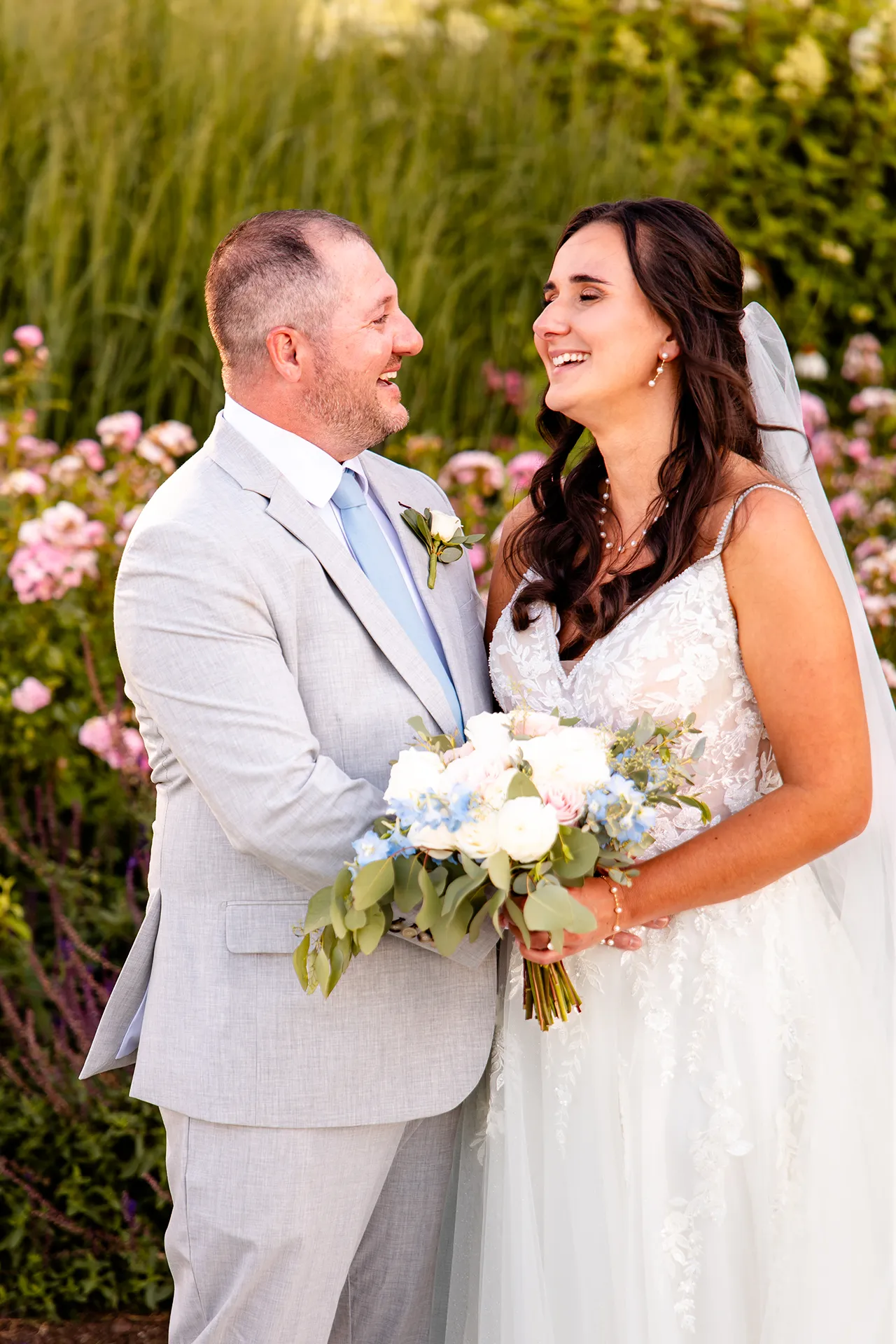 A newly married couple laugh together in a garden during wedding portraits at the Bar Harbor Inn and Spa in Bar Harbor, Maine.