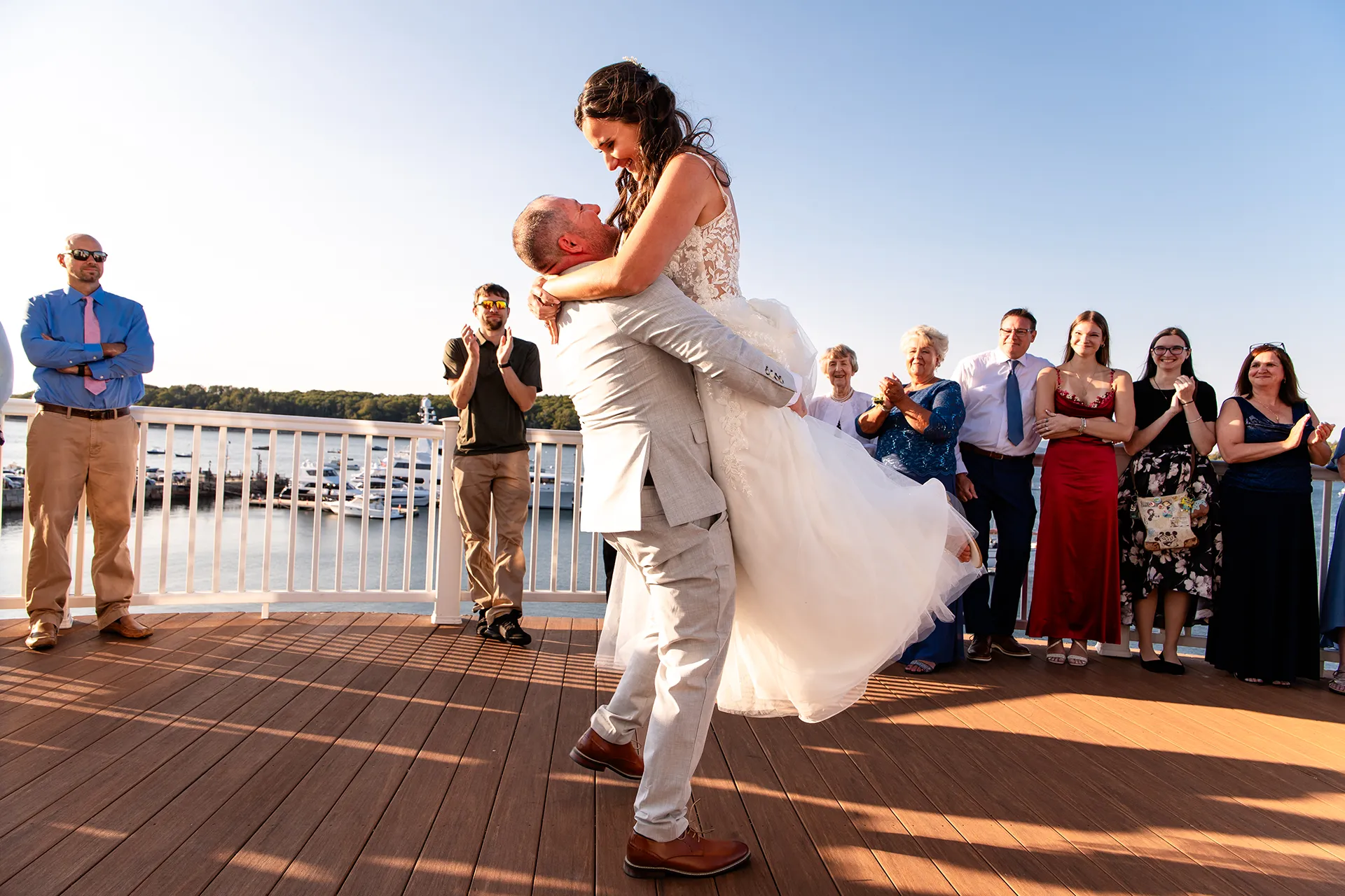 A groom picks up a bride during a first dance on the deck of the Porcupine Room at the Bar Harbor Inn and Spa in Bar Harbor, Maine.