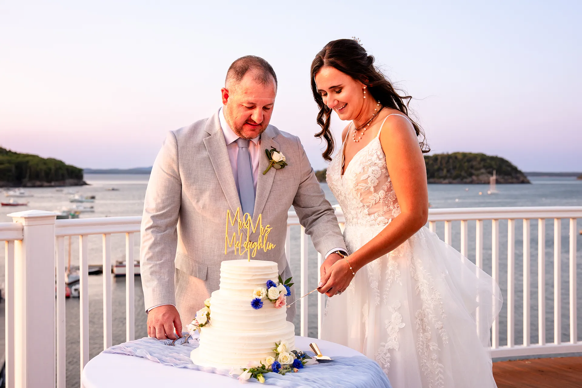 A bride and groom cut a wedding cake on the deck of the Porcupine Room at the Bar Harbor Inn and Spa in Bar Harbor, Maine.