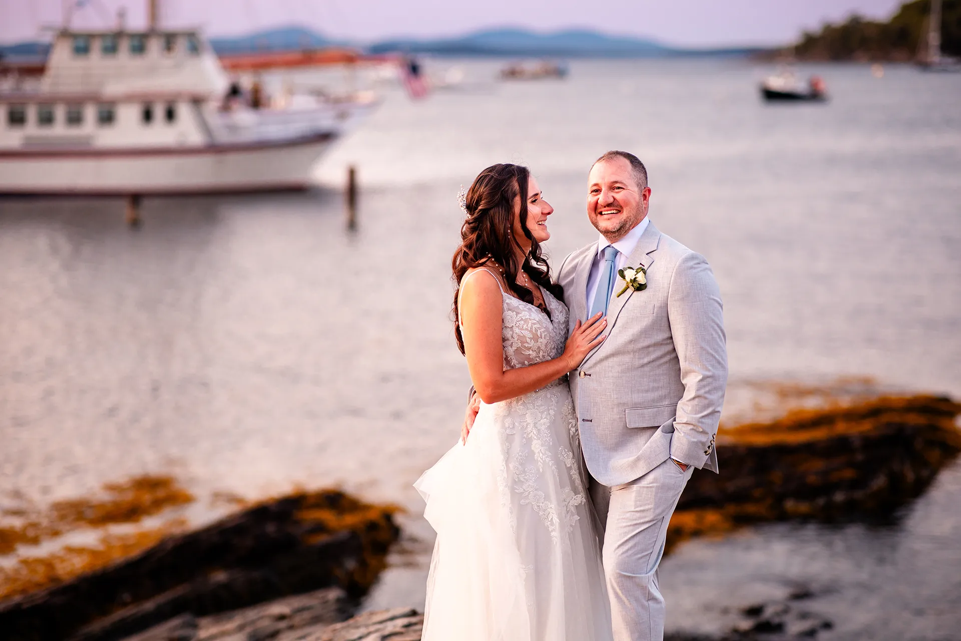 A newly married couple laugh while posing for wedding portraits near the Bar Harbor Inn and Spa in Bar Harbor, Maine.