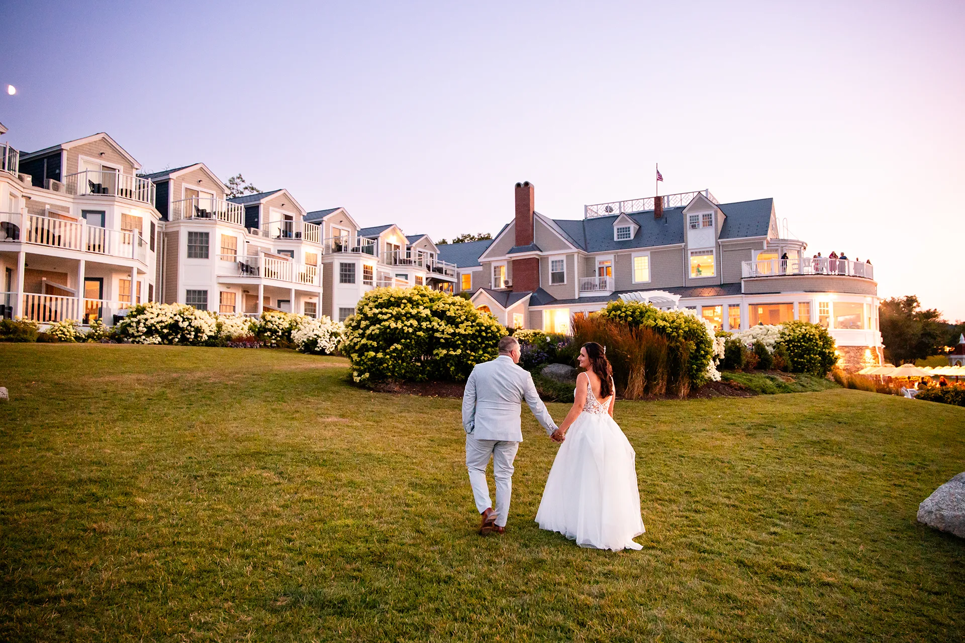 A bride and groom walk back to the Bar Harbor Inn and Spa during wedding portraits in Bar Harbor, Maine.