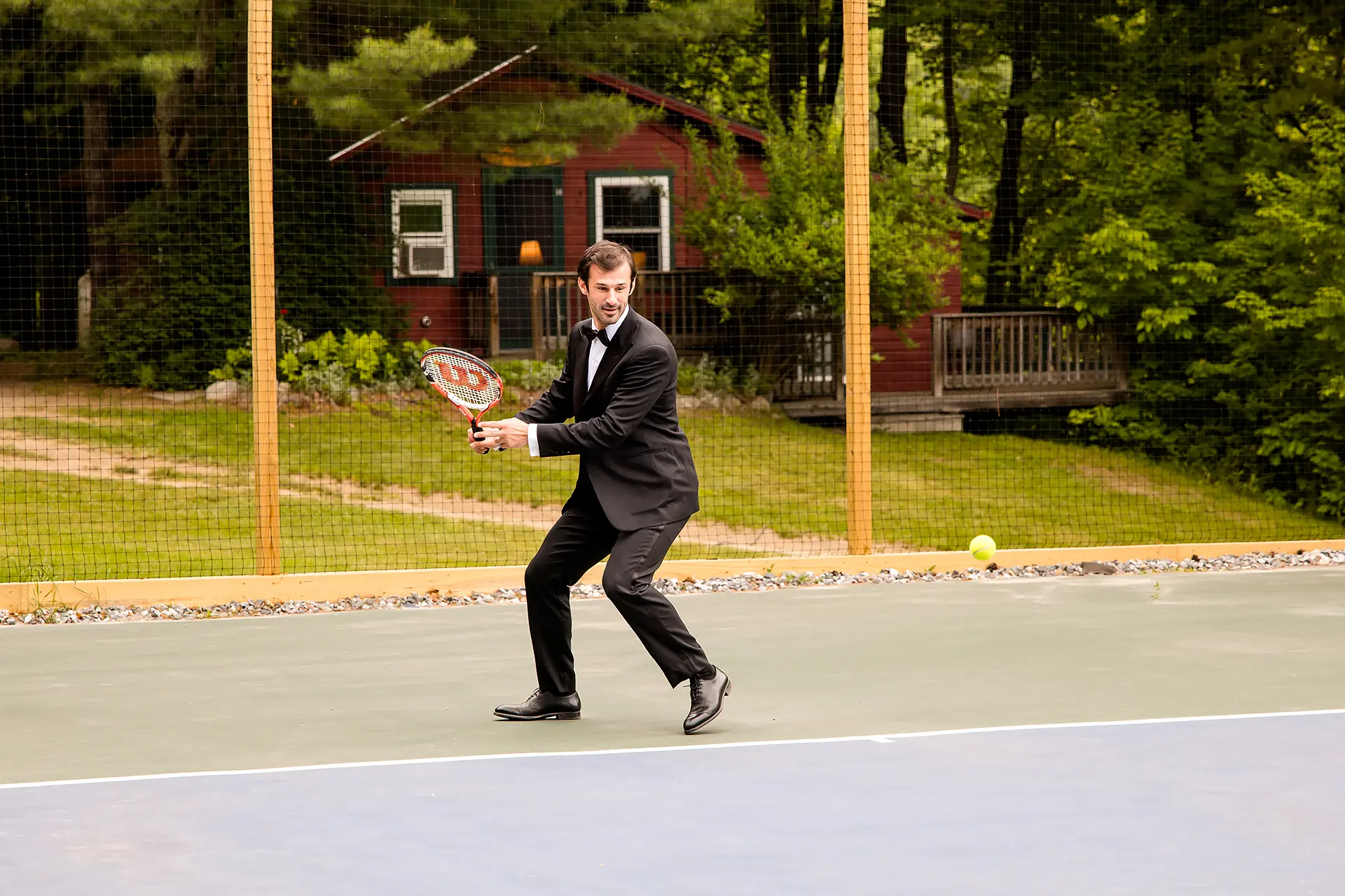 A groom plays tennis at the Kingsley Pines Camp In Raymond, Maine.