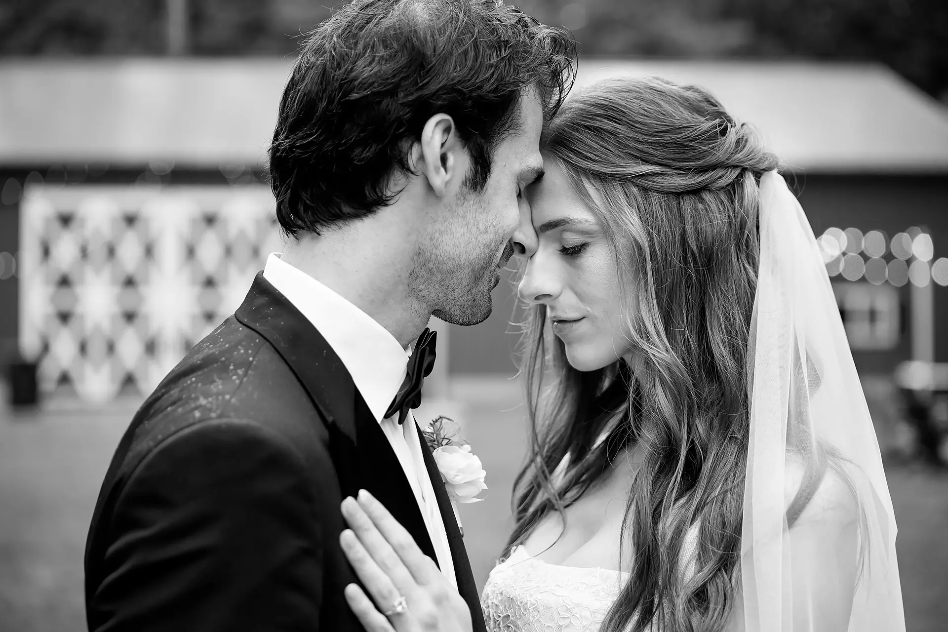 A bride and groom rest their head together during wedding portraits at Kingsley Pines Camp in Raymond, Maine.
