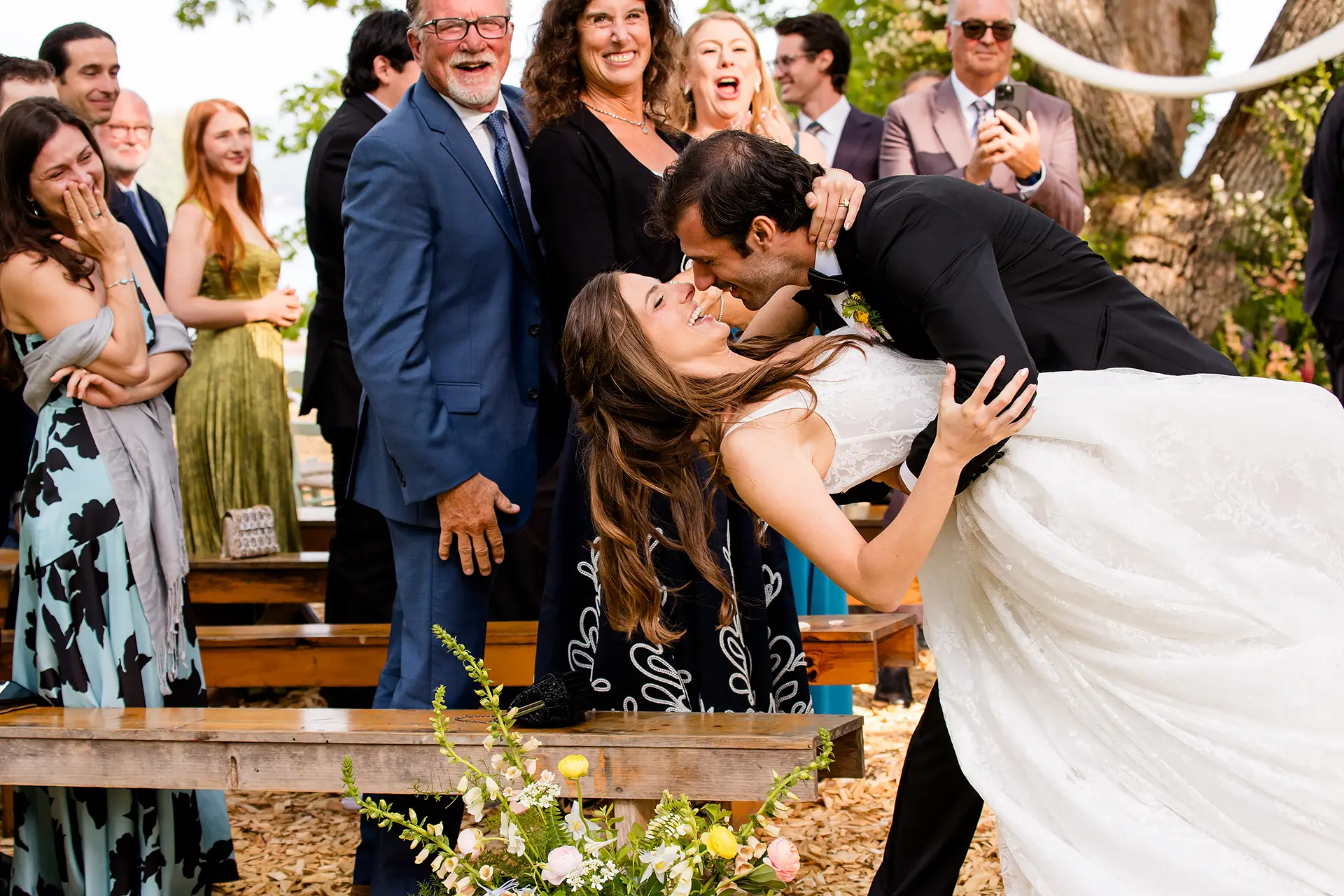A groom dips a bride as she laughs during a wedding ceremony at Kingsley Pines Camp in Raymond, Maine.