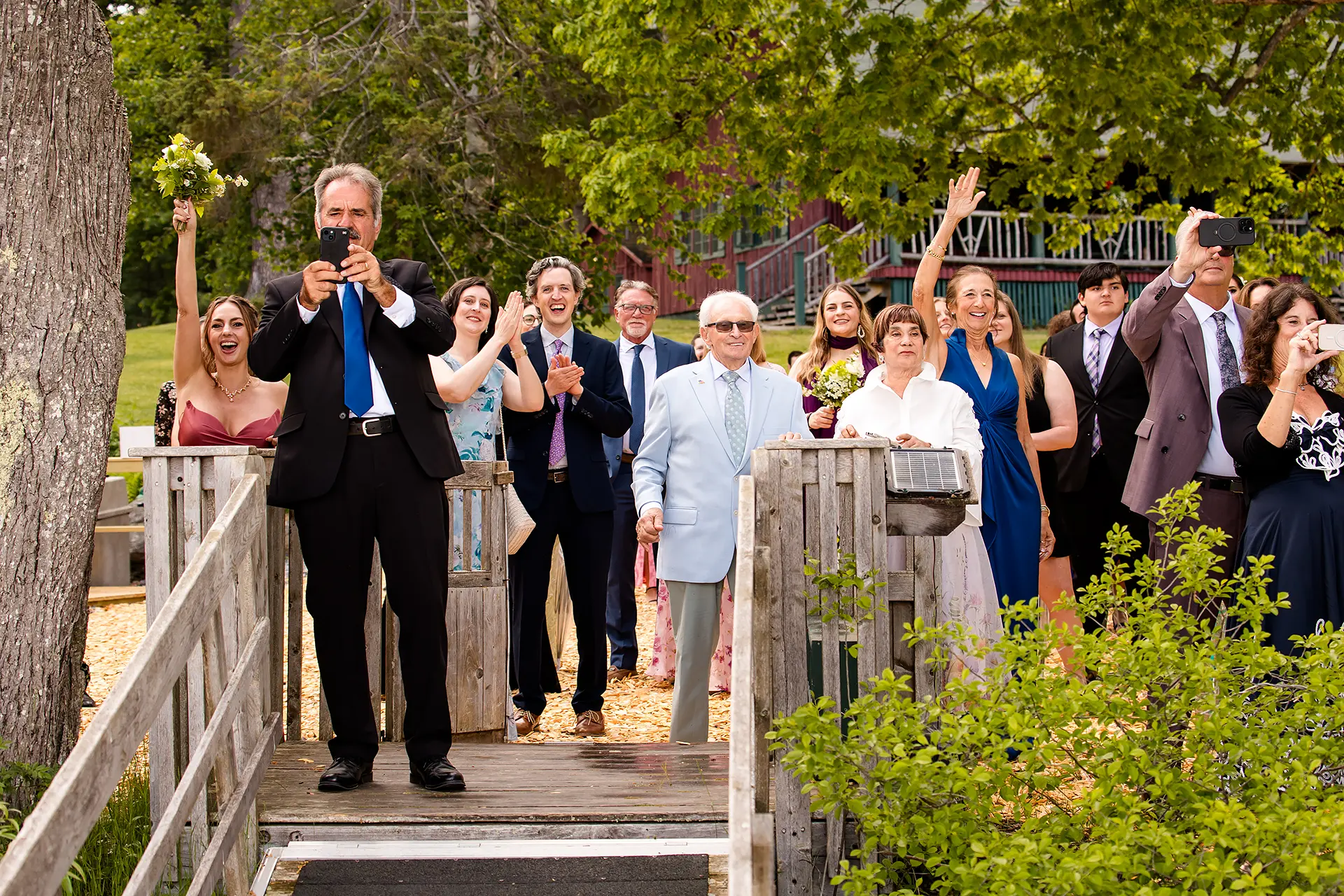Wedding guests cheer and wave as they watch a newly married couple get into a lake plane at Kingsley Pines Camp in Raymond, Maine.
