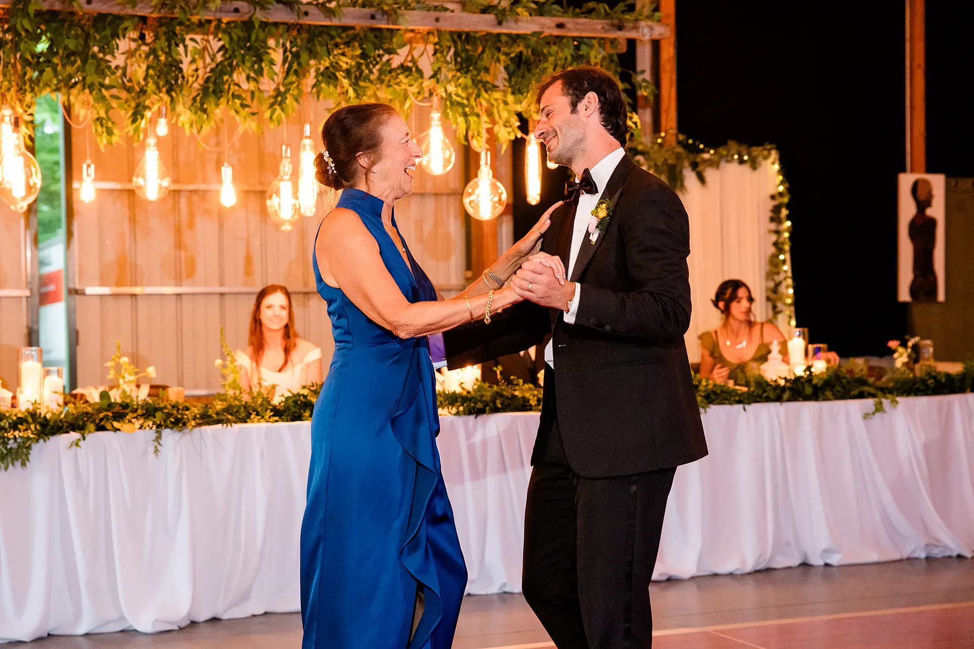 A groom and his mom laugh as they share a dance during a wedding reception at Kingsley Pines Camp in Raymond, Maine.