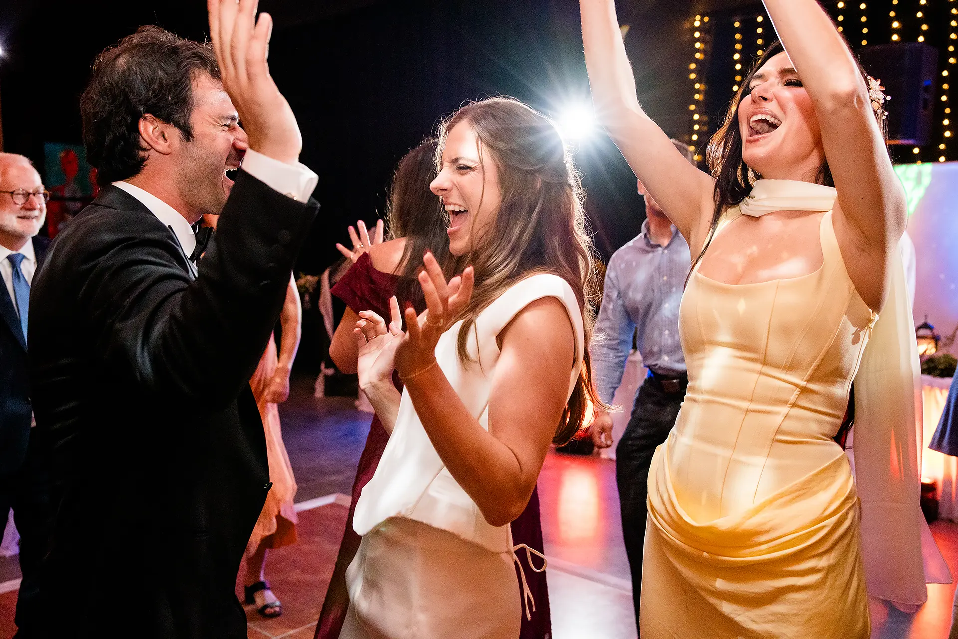 A bride and groom dance with guests during a wedding reception at Kingsley Pines Camp in Raymond, Maine.