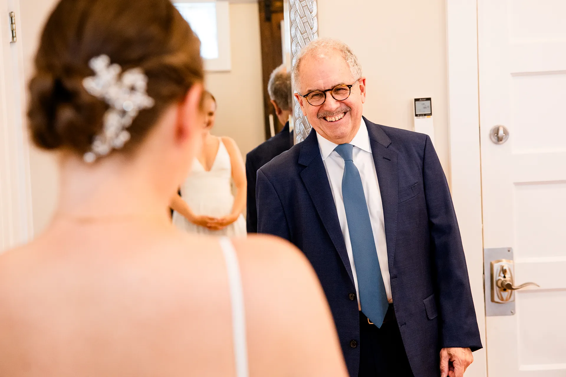 A dad smiles at a bride as he sees her in her wedding dress at the Nonantum Resort in Kennebunkport, Maine.