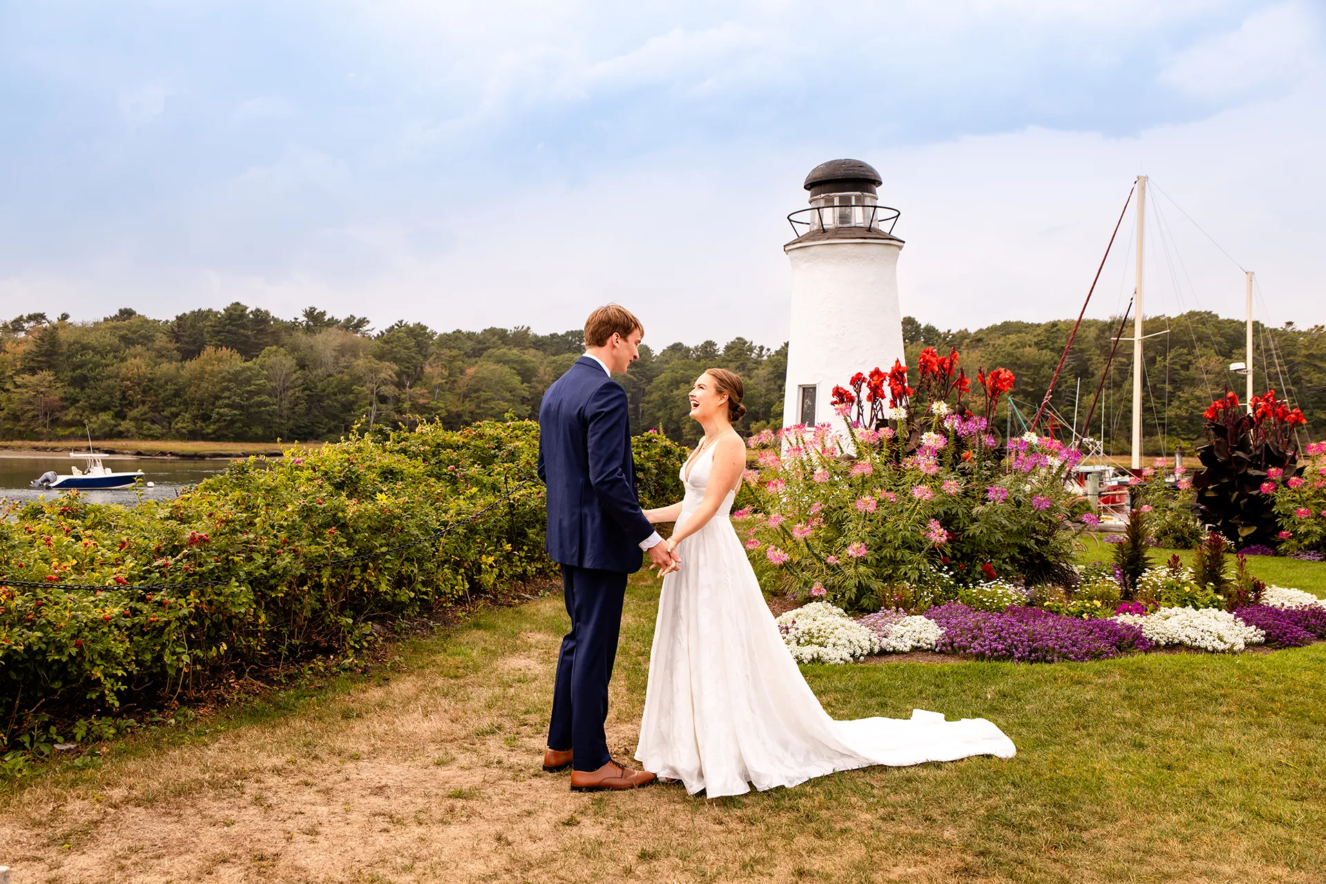 A bride laughs as she holds a groom's hand during a first look at the Nonantum Resort in Kennebunkport, Maine.