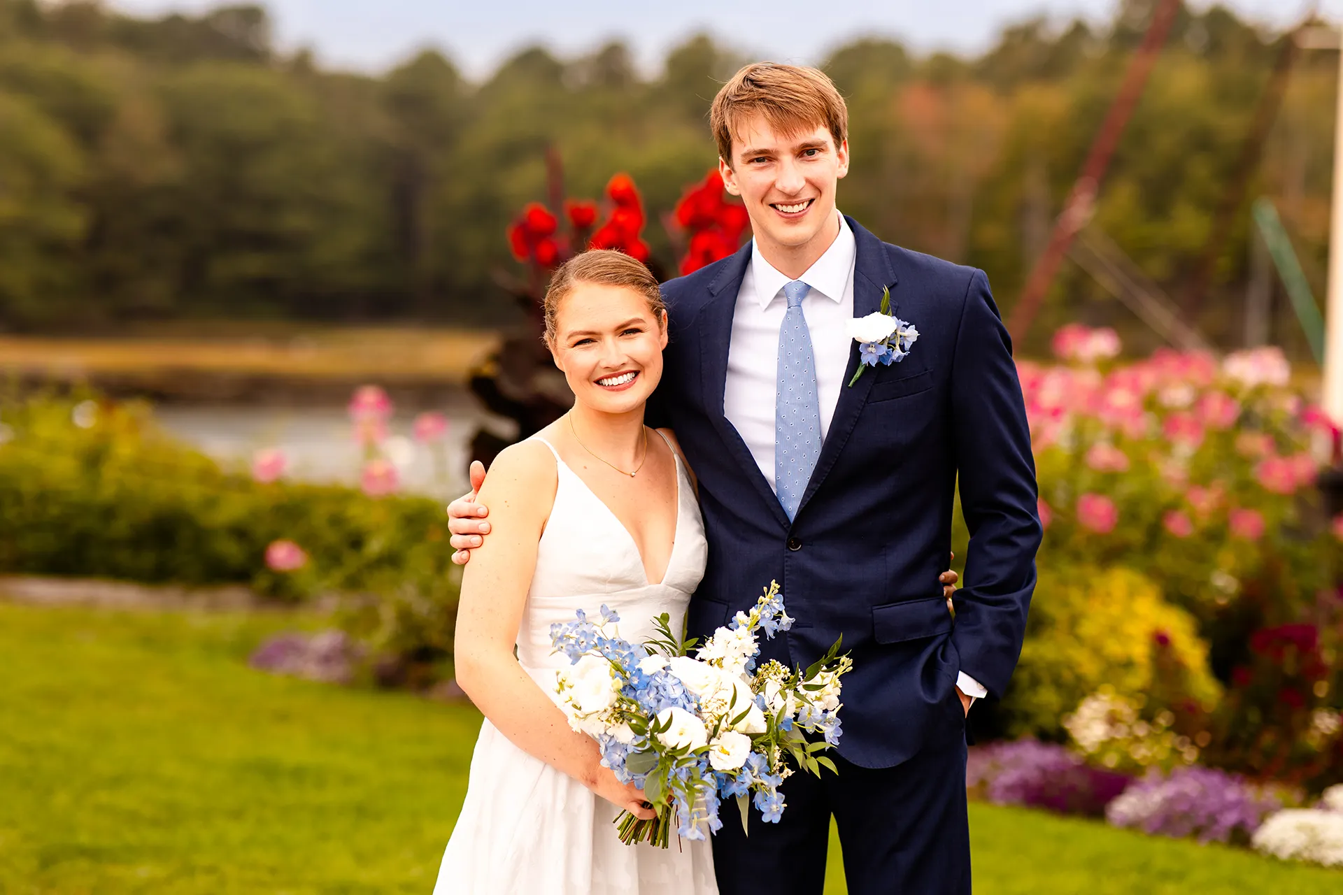 A bride and groom smile and pose during wedding portraits at the Nonantum Resort in Kennebunkport, Maine.