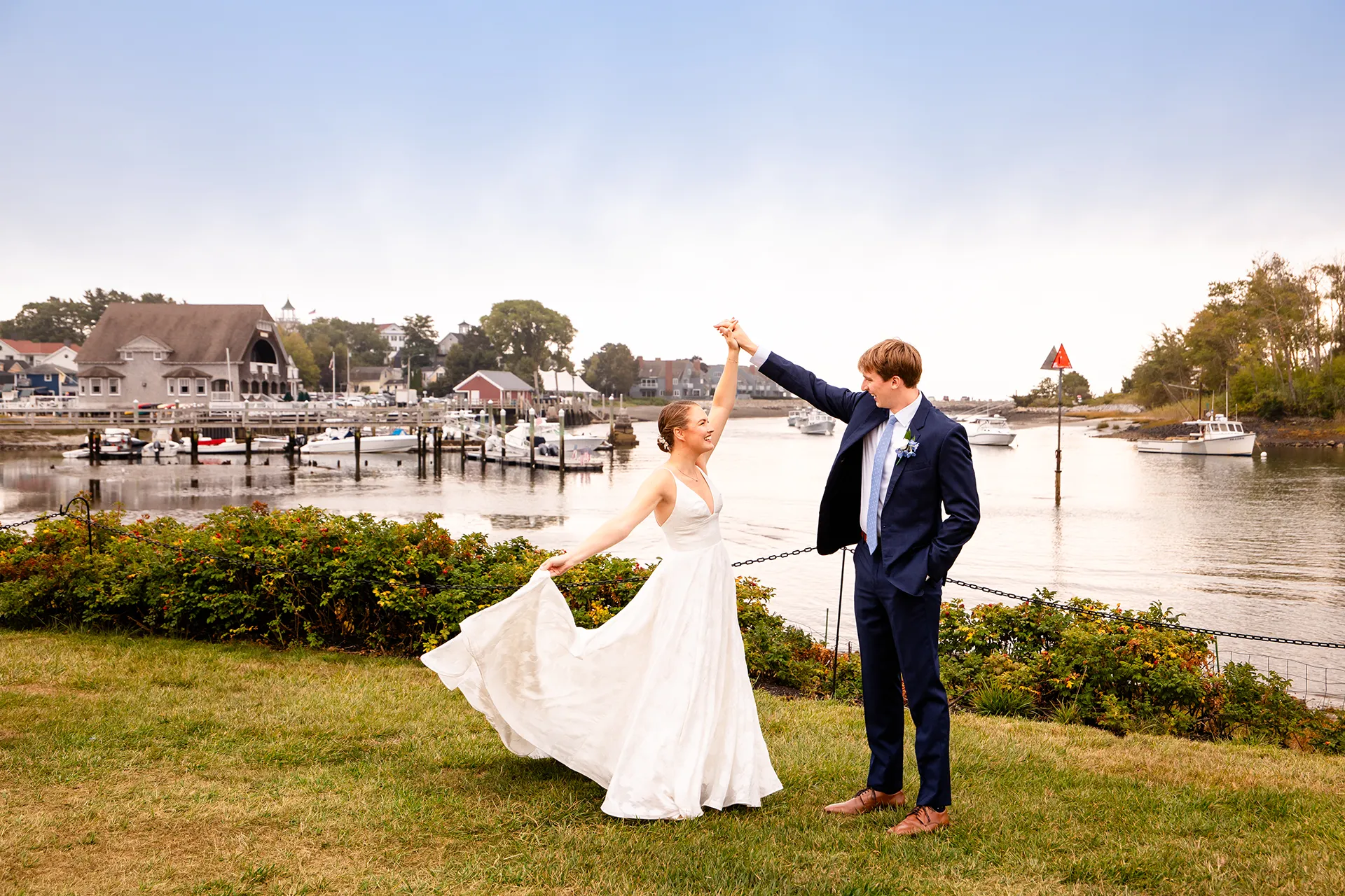 A bride smile at a groom as she hold her dress during wedding portraits at the Nonantum Resort in Kennebunkport, Maine.