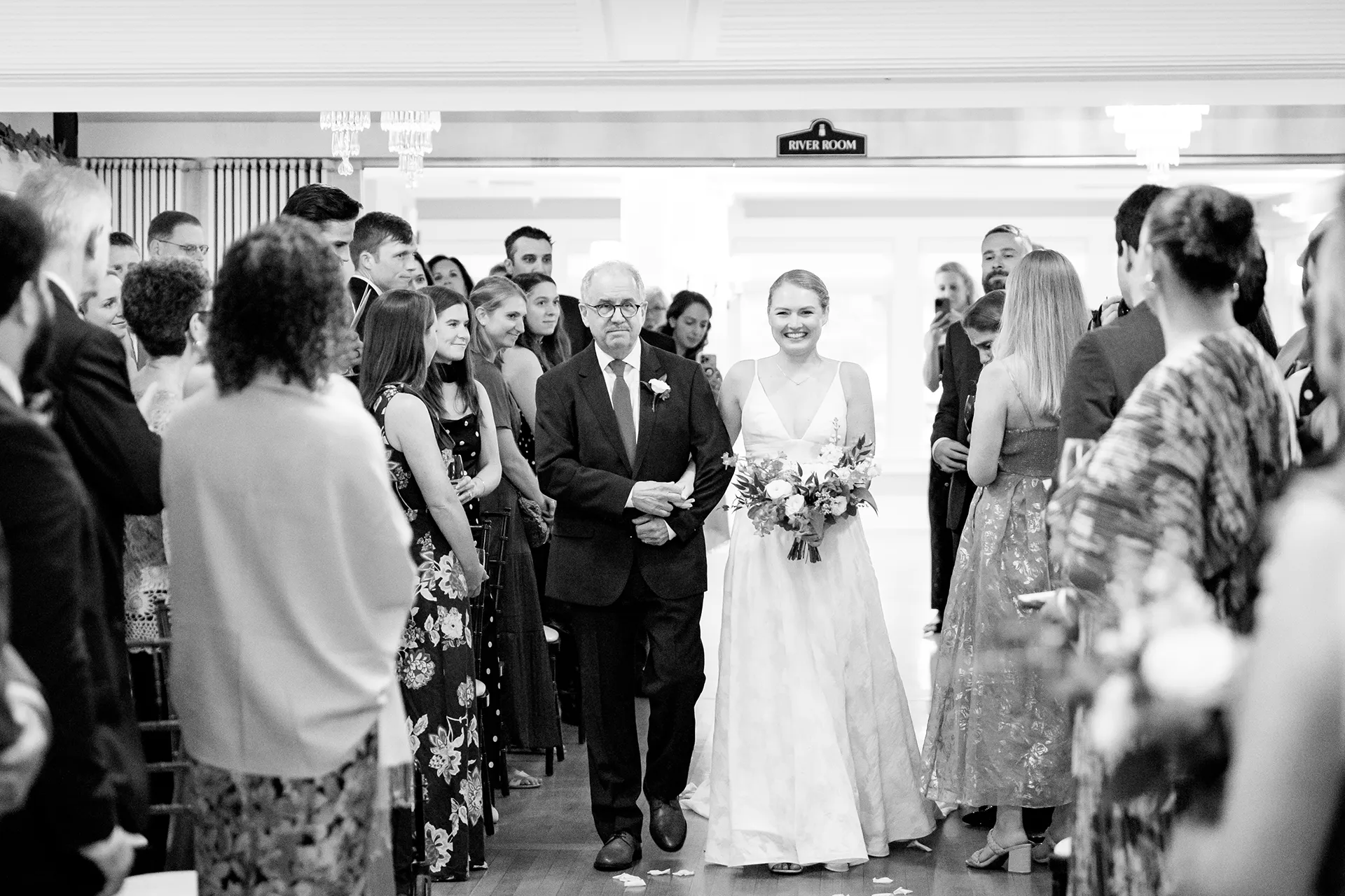 A bride and her dad walk down the aisle during a wedding ceremony at the Nonantum Resort in Kennebunkport, Maine.