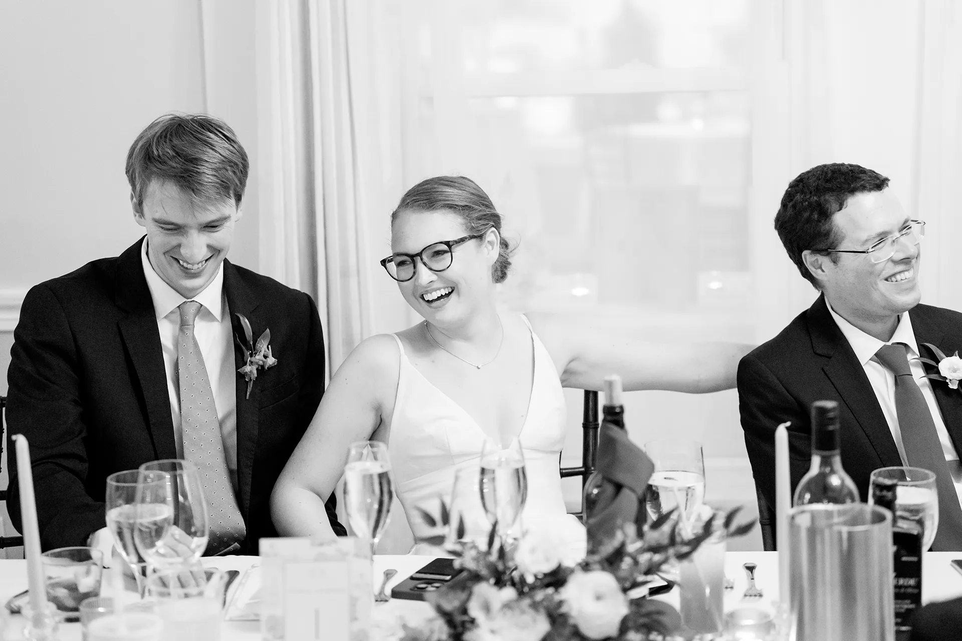A bride and groom laugh as they listen to a toast during a wedding reception at the Nonantum Resort in Kennebunkport, Maine.
