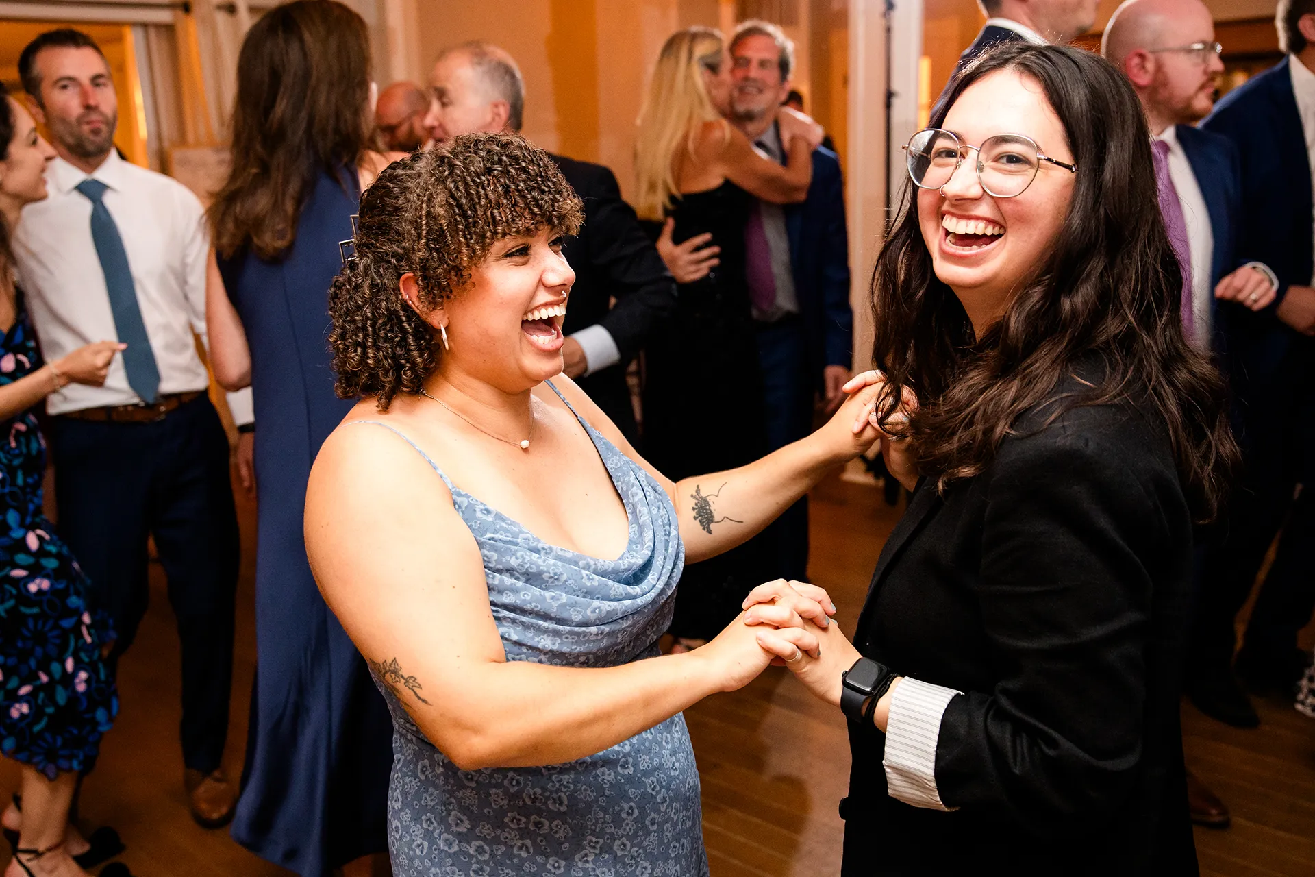 Two ladies laugh as they dance during a wedding reception at the Nonantum Resort in Kennebunkport, Maine.